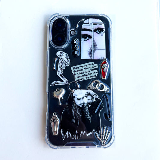 $uicideboy$ g59 phone case featuring a gothic horror-themed design with silver and black charms, including a skeleton, a skull, a vampire illustration, a small coffin, and a quote bubble that reads, 'They figure me a dead motherfucker but I'm just a motherfucker who wants to be dead.'.