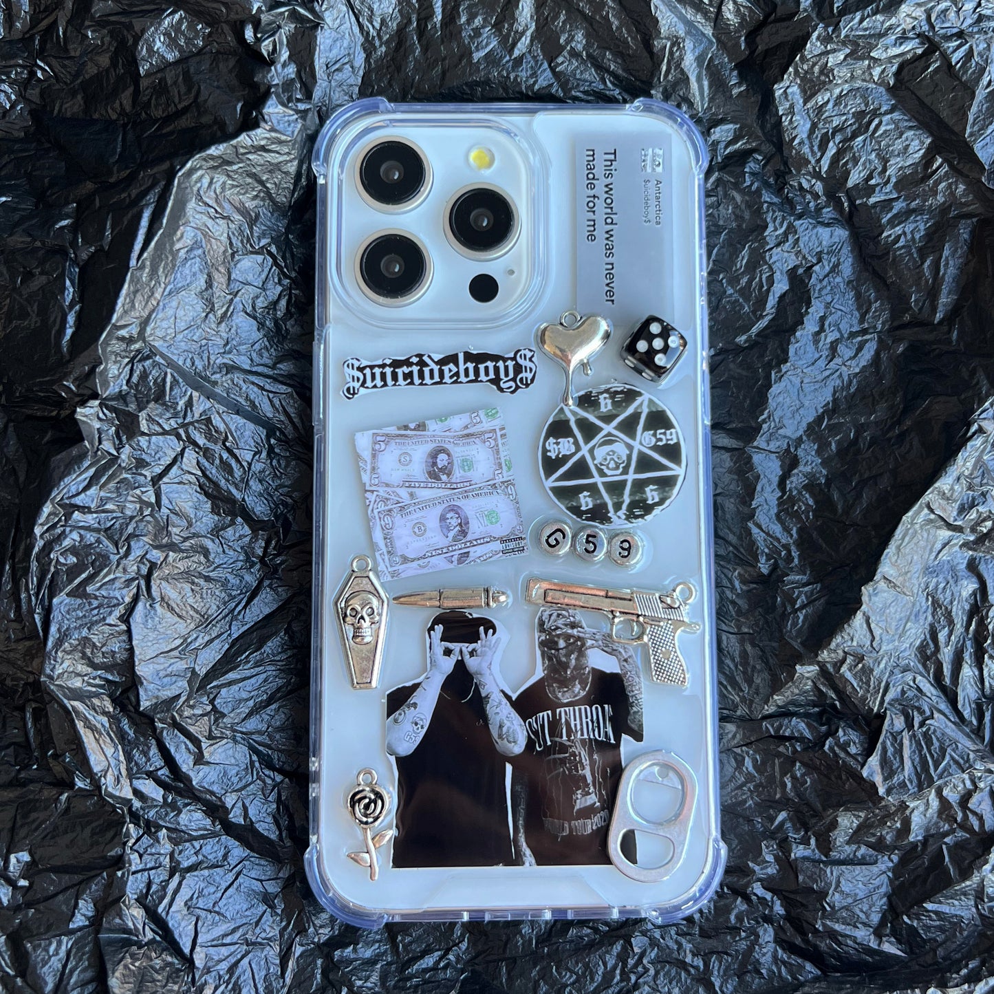 custom $uicideboy$ g59 phone case with a gothic-themed collage design, including a 'Suicideboy' graphic,Antarctica lyrics, dollar bill, dice, pentagram, coffin, gun, and band t-shirt print, shown on a black background.