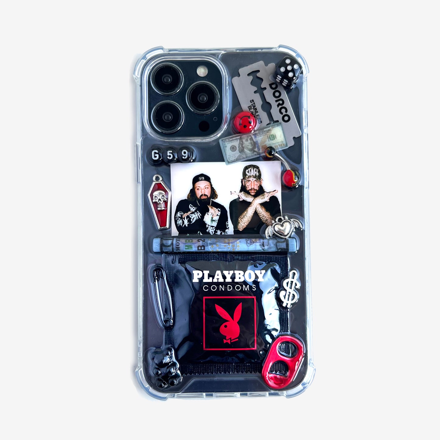 suicideboys phone case featuring a collage of heavy metal and rock-themed stickers and charms, including a 'Playboy Condoms' logo, a 'Tobacco' band sticker, a 'g59' graphic, and a photo of the band members, shown on a light white background.